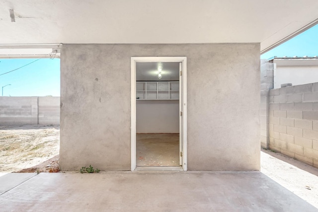 entrance to property with fence and stucco siding