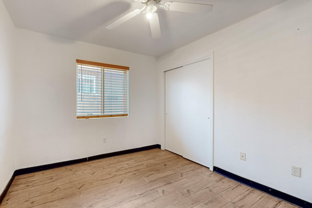 unfurnished bedroom featuring baseboards, light wood-type flooring, a closet, and ceiling fan