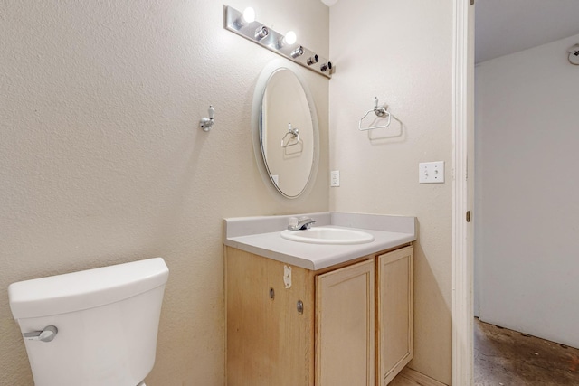 half bath with toilet, unfinished concrete floors, and vanity