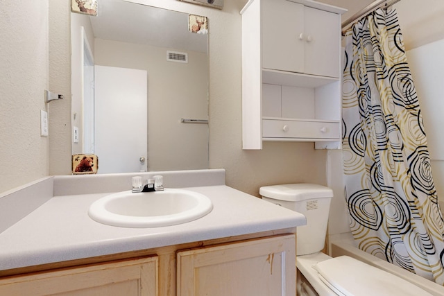 full bath featuring visible vents, toilet, vanity, and shower / bath combo with shower curtain