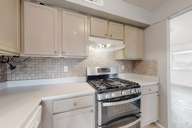 kitchen with visible vents, range with two ovens, decorative backsplash, light countertops, and under cabinet range hood