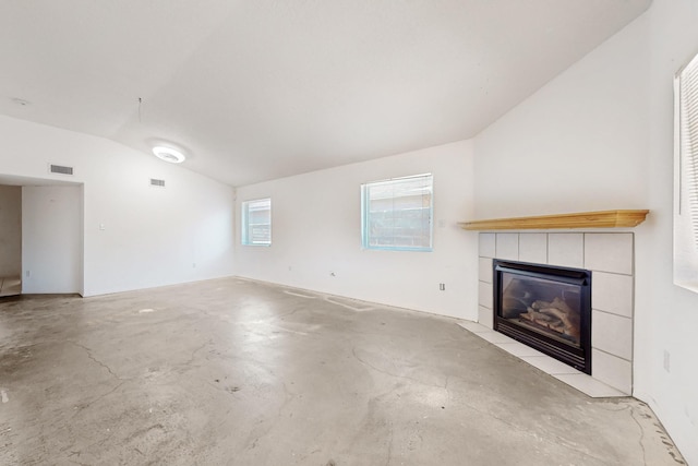 unfurnished living room featuring visible vents, lofted ceiling, concrete flooring, and a fireplace