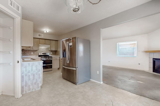 kitchen with light countertops, visible vents, under cabinet range hood, and stainless steel appliances