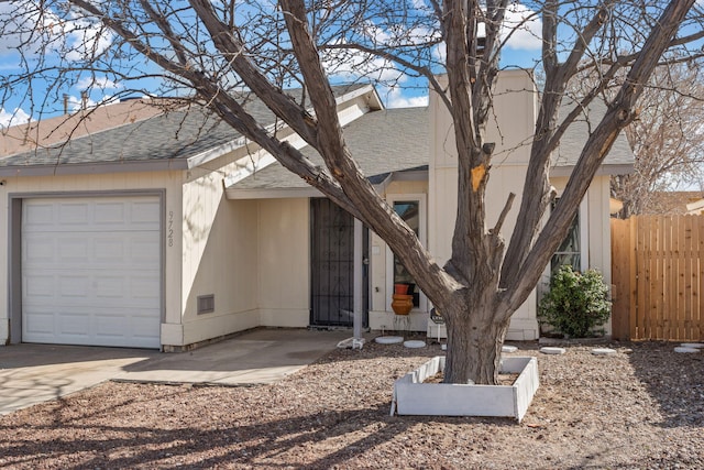 view of front of property with fence, a garage, driveway, and a shingled roof