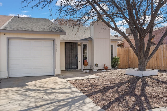 ranch-style home with an attached garage, fence, and roof with shingles