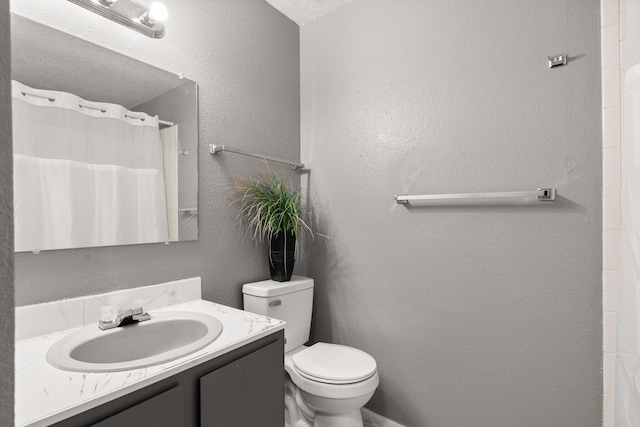 full bath featuring a shower with curtain, toilet, vanity, and a textured wall