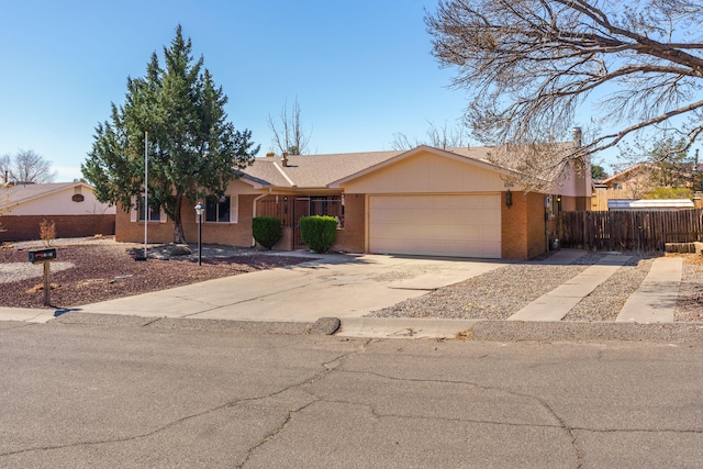 ranch-style house with a garage, brick siding, driveway, and fence