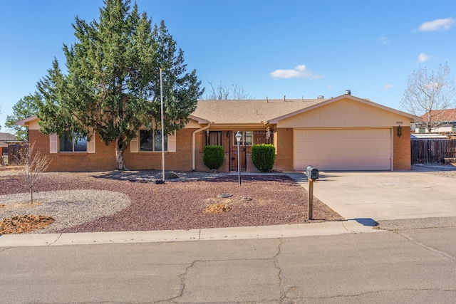 ranch-style home featuring brick siding, an attached garage, driveway, and fence