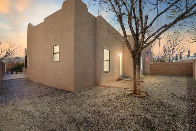 back of house with a patio, fence private yard, and stucco siding