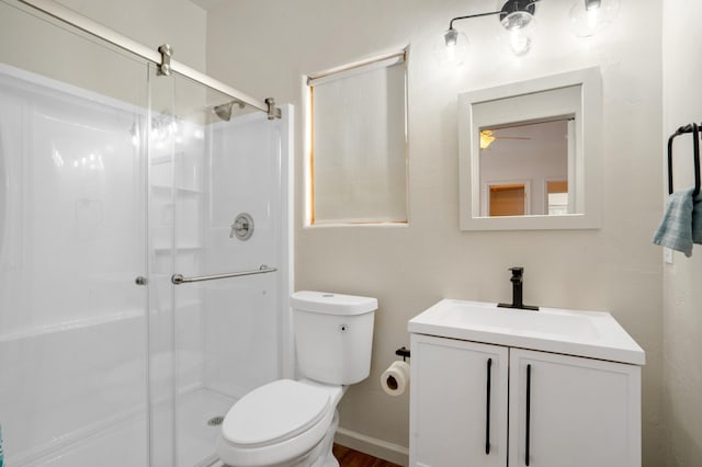 bathroom featuring a shower stall, toilet, vanity, and a ceiling fan