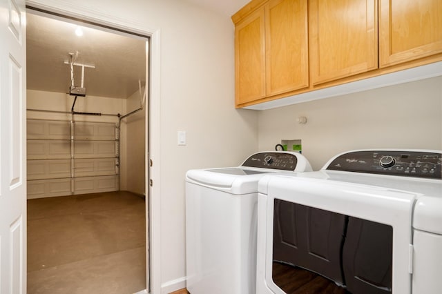 clothes washing area featuring cabinet space and washing machine and dryer