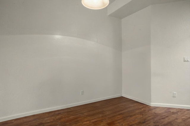 unfurnished room featuring dark wood finished floors and baseboards