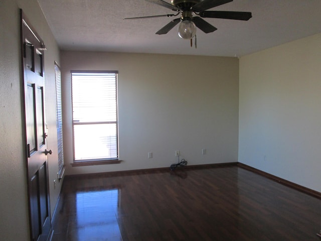 spare room with a textured ceiling, wood finished floors, baseboards, and ceiling fan