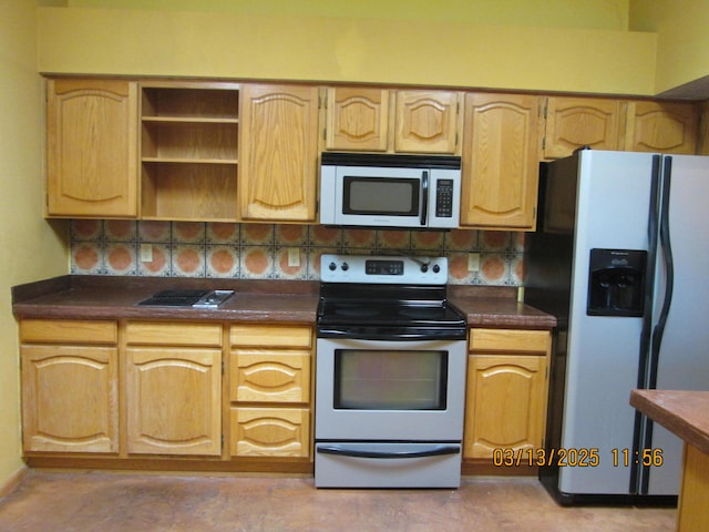 kitchen with dark countertops, light brown cabinets, and stainless steel appliances