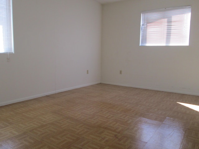 spare room featuring baseboards and a healthy amount of sunlight