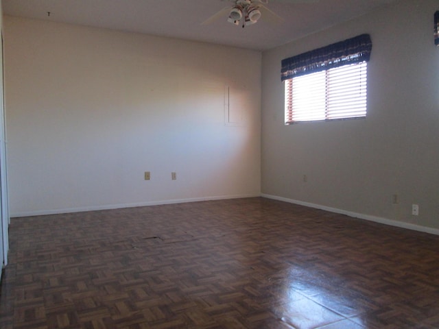 empty room featuring a ceiling fan and baseboards