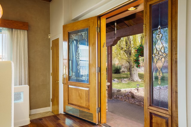 entryway with baseboards and dark wood-style flooring