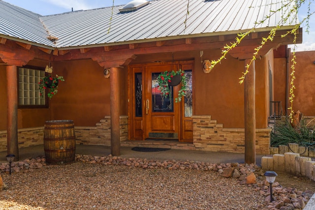 property entrance featuring metal roof and stone siding