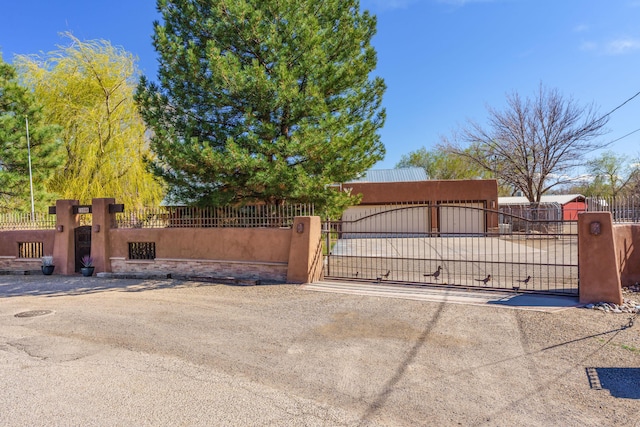 view of gate with a fenced front yard