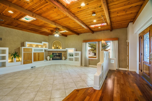 unfurnished living room featuring visible vents, baseboards, beamed ceiling, and wooden ceiling