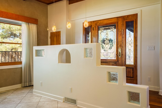 foyer with tile patterned floors, baseboards, and visible vents