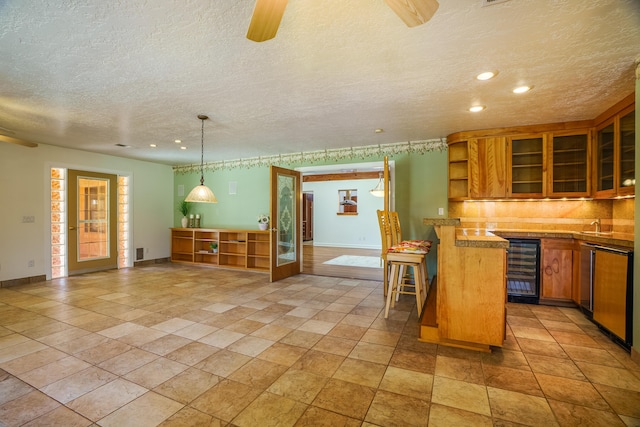 kitchen with glass insert cabinets, wine cooler, a breakfast bar area, brown cabinetry, and open shelves