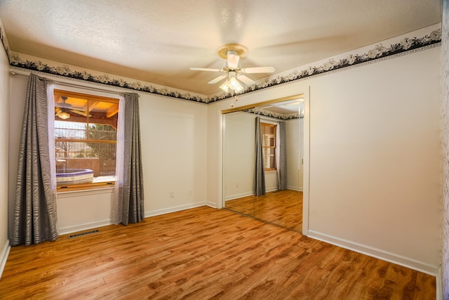 spare room featuring visible vents, a ceiling fan, a textured ceiling, light wood finished floors, and baseboards