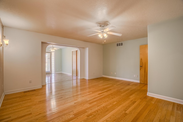 unfurnished room featuring light wood-style flooring, visible vents, and ceiling fan