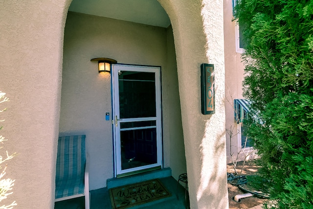 doorway to property featuring stucco siding