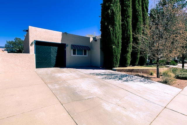 view of front of house with concrete driveway and stucco siding