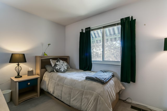 carpeted bedroom featuring visible vents