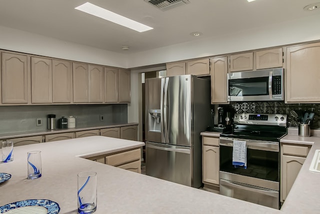 kitchen with tasteful backsplash, visible vents, stainless steel appliances, and light countertops