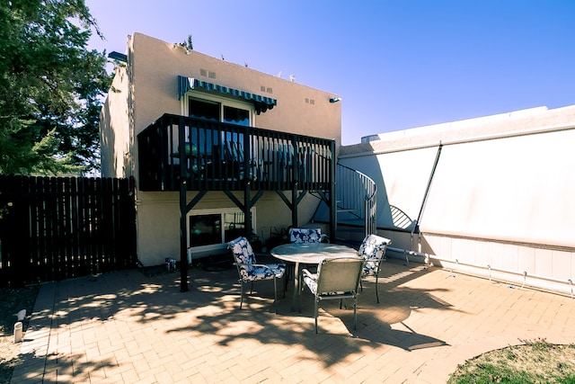 exterior space featuring outdoor dining area, stairs, and fence