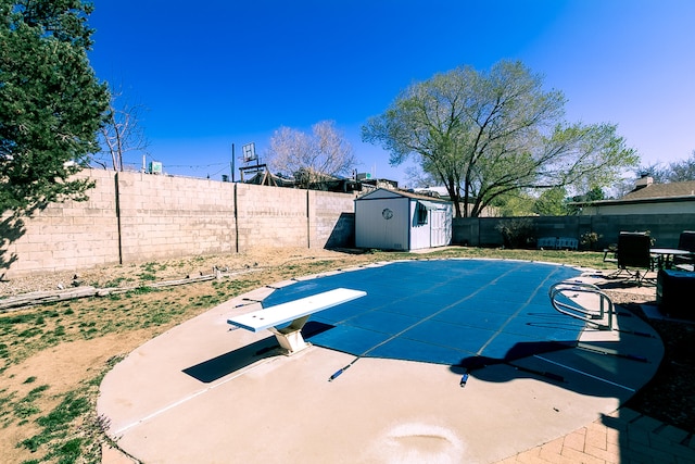 view of swimming pool featuring a patio area, a storage shed, a fenced backyard, and an outdoor structure