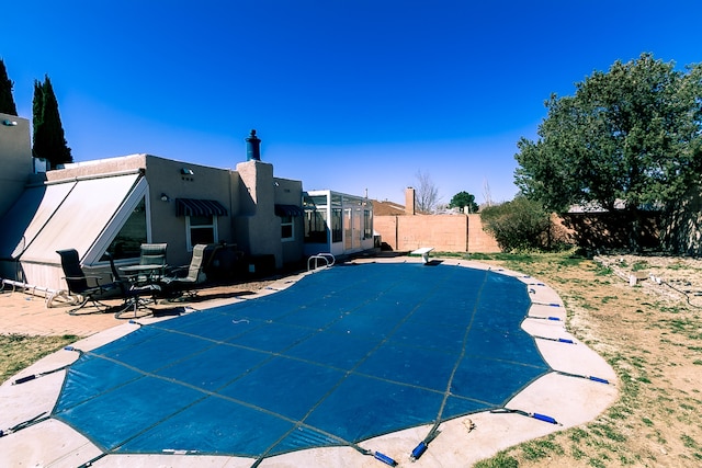 view of swimming pool featuring a patio and a fenced backyard