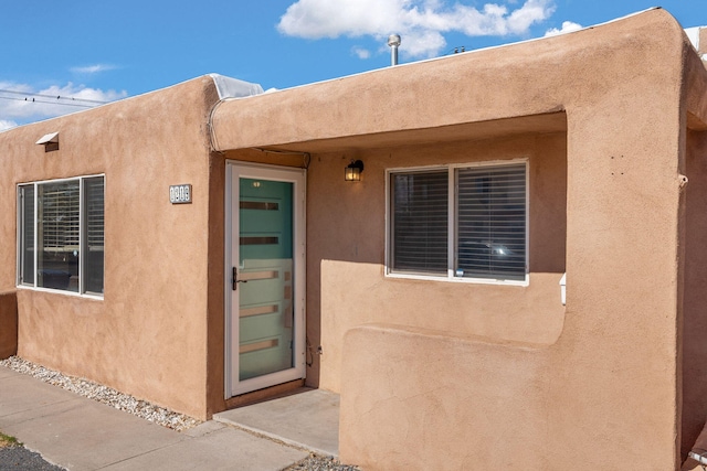 doorway to property featuring stucco siding