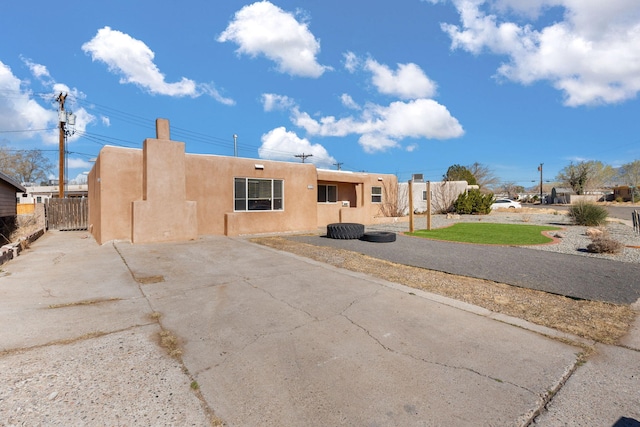 view of front of property with stucco siding and fence