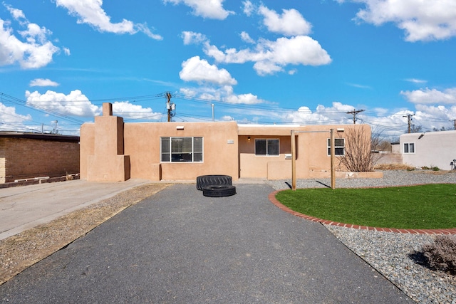 view of front of home with stucco siding and a front yard