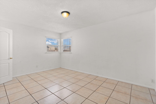 spare room with baseboards and a textured ceiling