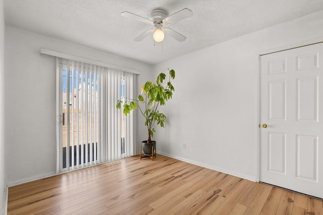 spare room featuring a textured ceiling, ceiling fan, and light wood finished floors