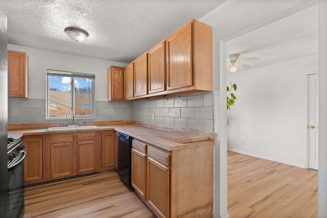 kitchen featuring light wood finished floors, black appliances, a ceiling fan, and a sink