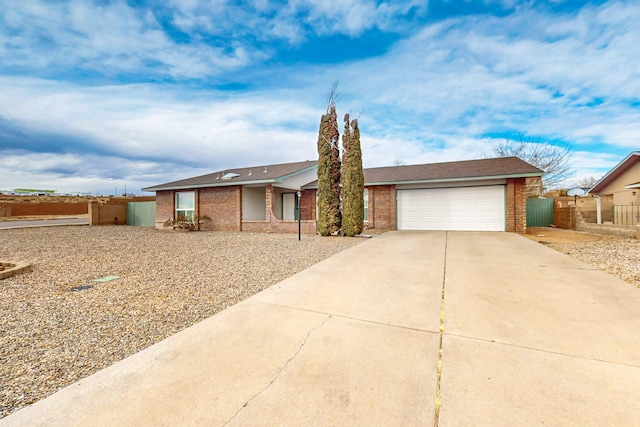 single story home with a garage, fence, brick siding, and driveway