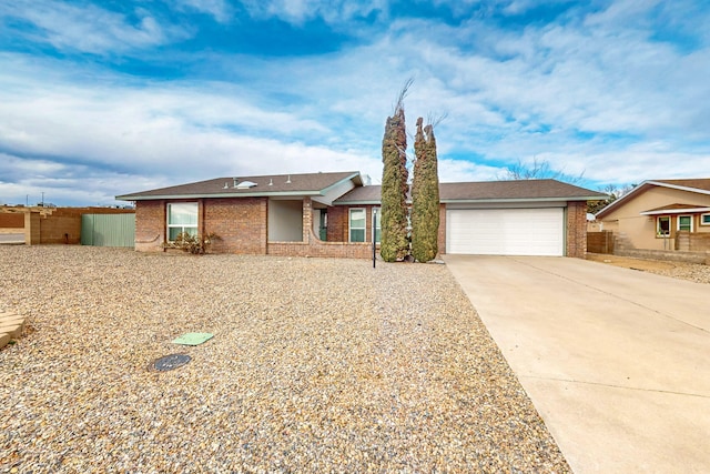 single story home with brick siding, concrete driveway, an attached garage, and fence