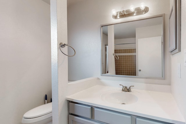 bathroom with toilet, walk in shower, and vanity