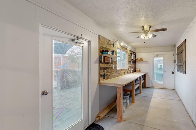 interior space with open shelves, a textured ceiling, concrete flooring, and a ceiling fan