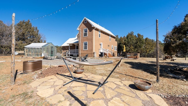 rear view of property with stucco siding, an outbuilding, a patio, an exterior structure, and cooling unit