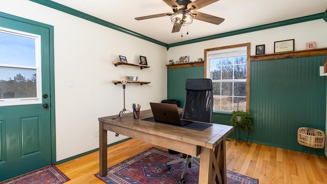 home office featuring light wood finished floors, baseboards, a ceiling fan, and ornamental molding