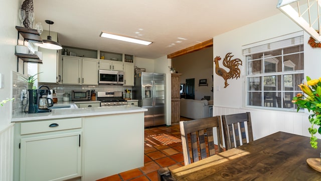 kitchen featuring a sink, appliances with stainless steel finishes, a peninsula, and light countertops