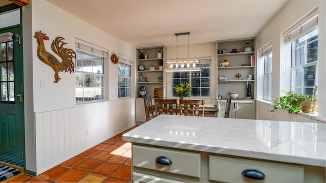 kitchen with plenty of natural light, a wainscoted wall, and open shelves