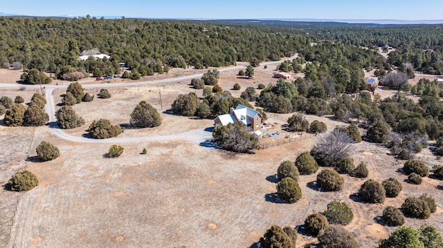 drone / aerial view featuring a wooded view